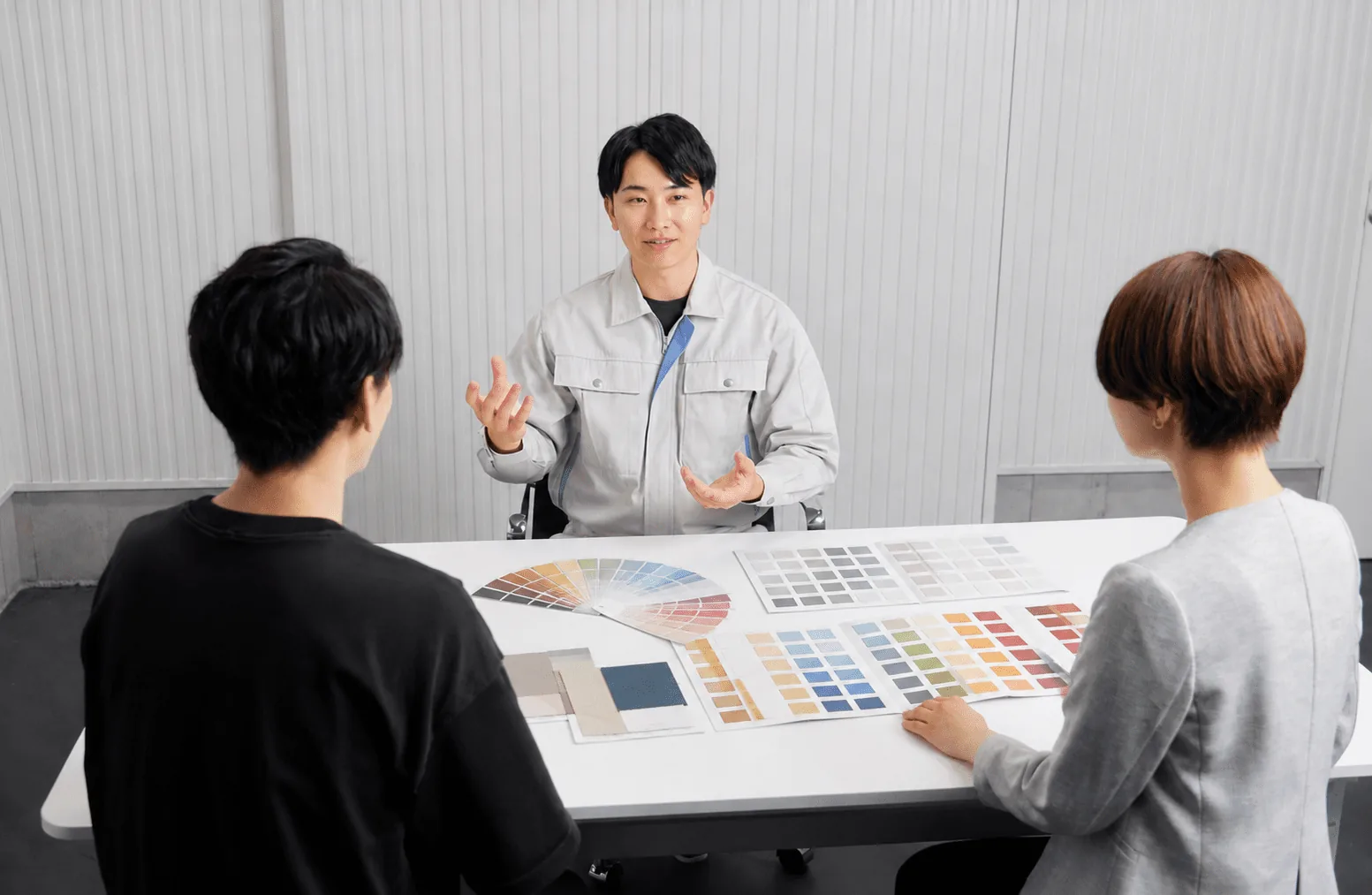 テーブルに色見本を広げてお客様へ説明している様子