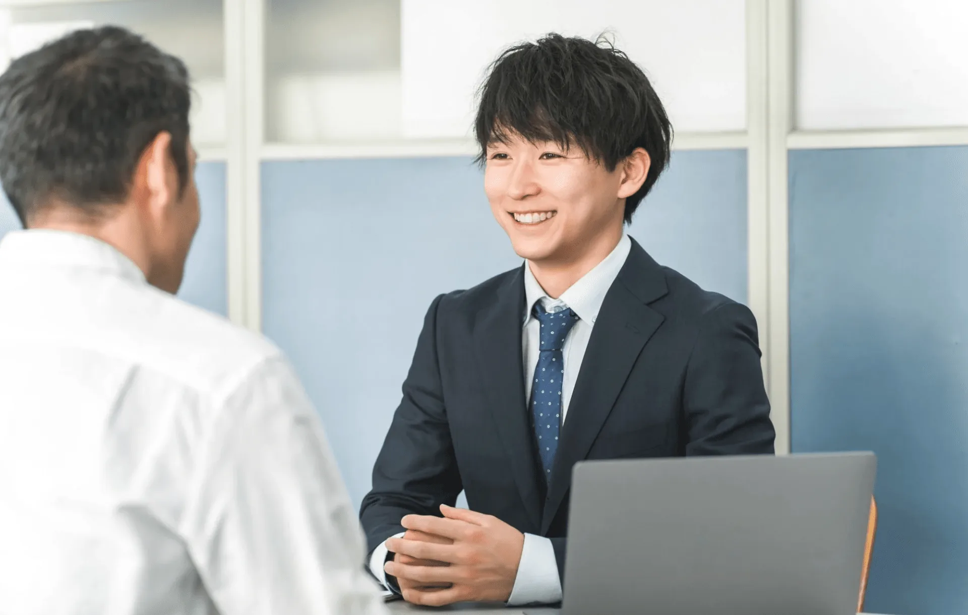 打ち合わせテーブルでお客様の相談を受けているスタッフ